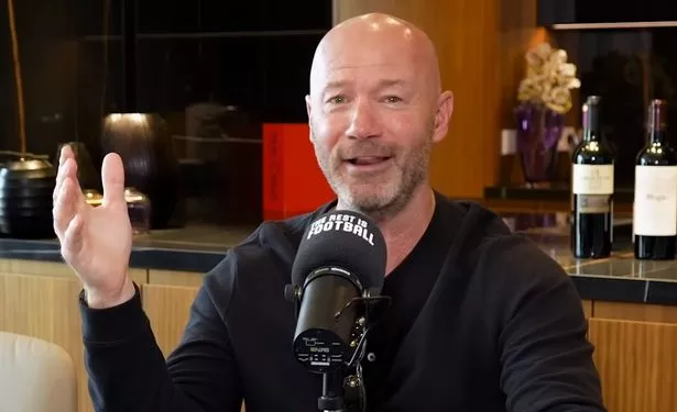 Alan Shearer speaking into a microphone and smiling during a podcast appearance